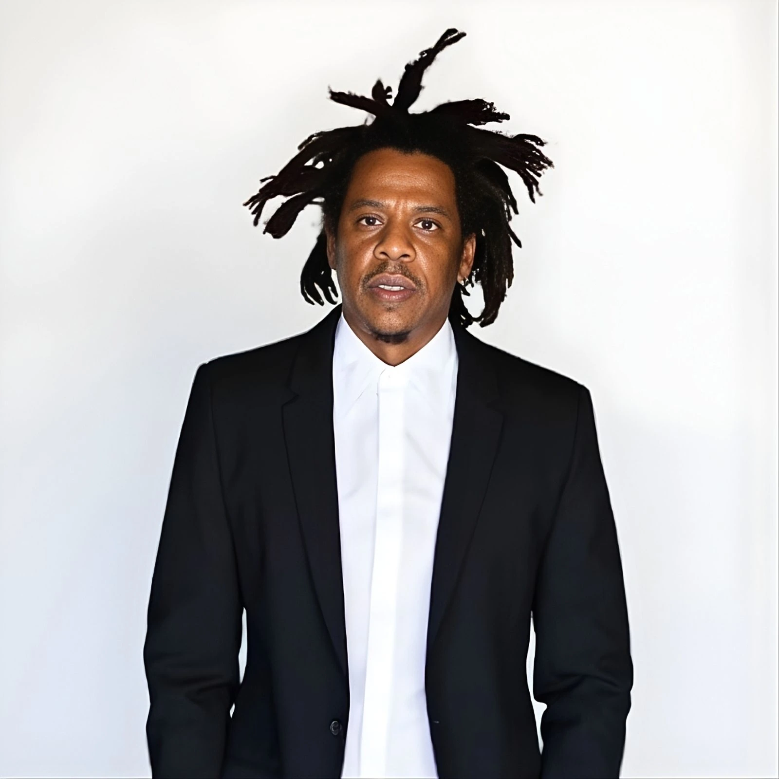 Jay-Z, the American rapper and entrepreneur, in a formal portrait wearing a black suit and white shirt.